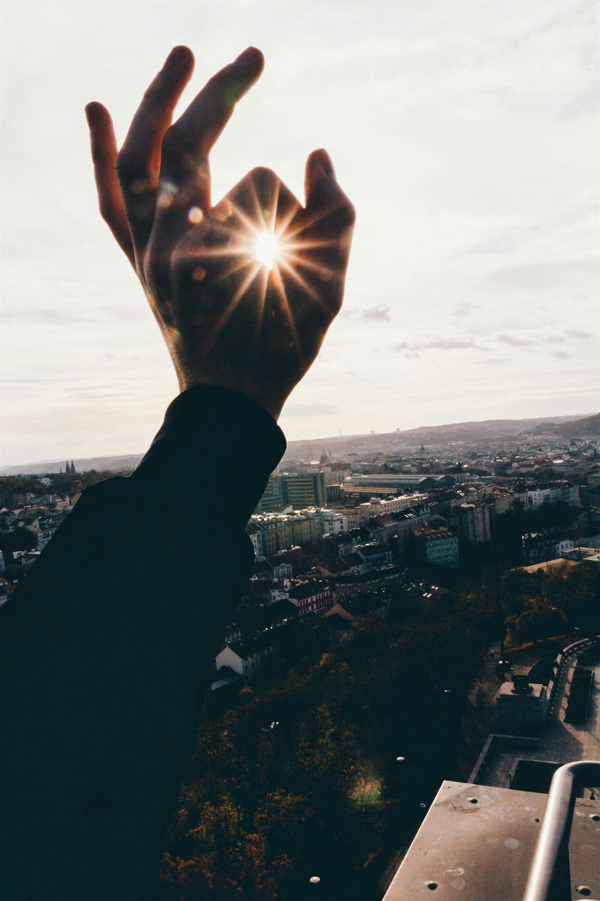Eine Hand hält das Sonnenlicht über einer Stadt als Sinnbild für Klarheit und Ressourcen